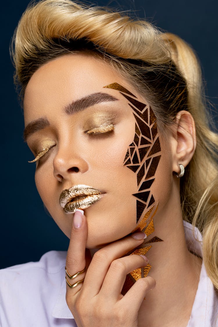 Sensual Model With Golden Makeup Touching Lips