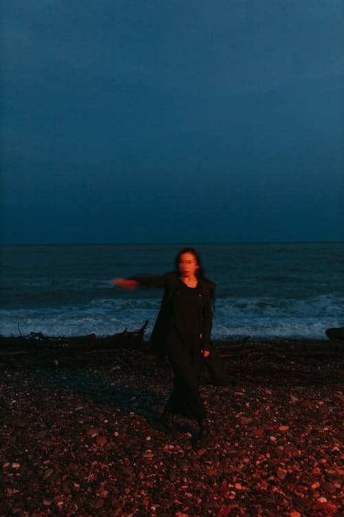 Woman in Black Dress Standing on Beach