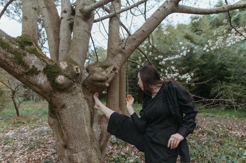Woman Stretching Legs Beside Tree