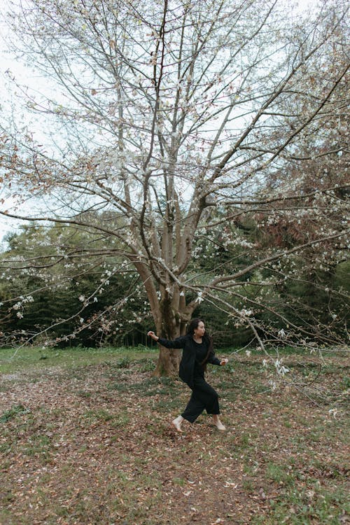 Woman Dancing Under a Leafless Tree