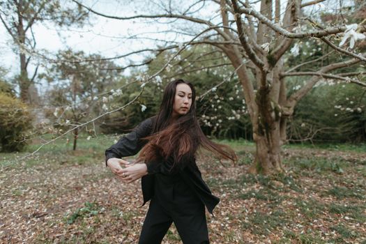 Woman in Black Long Sleeve Shirt Standing Near Bare Trees