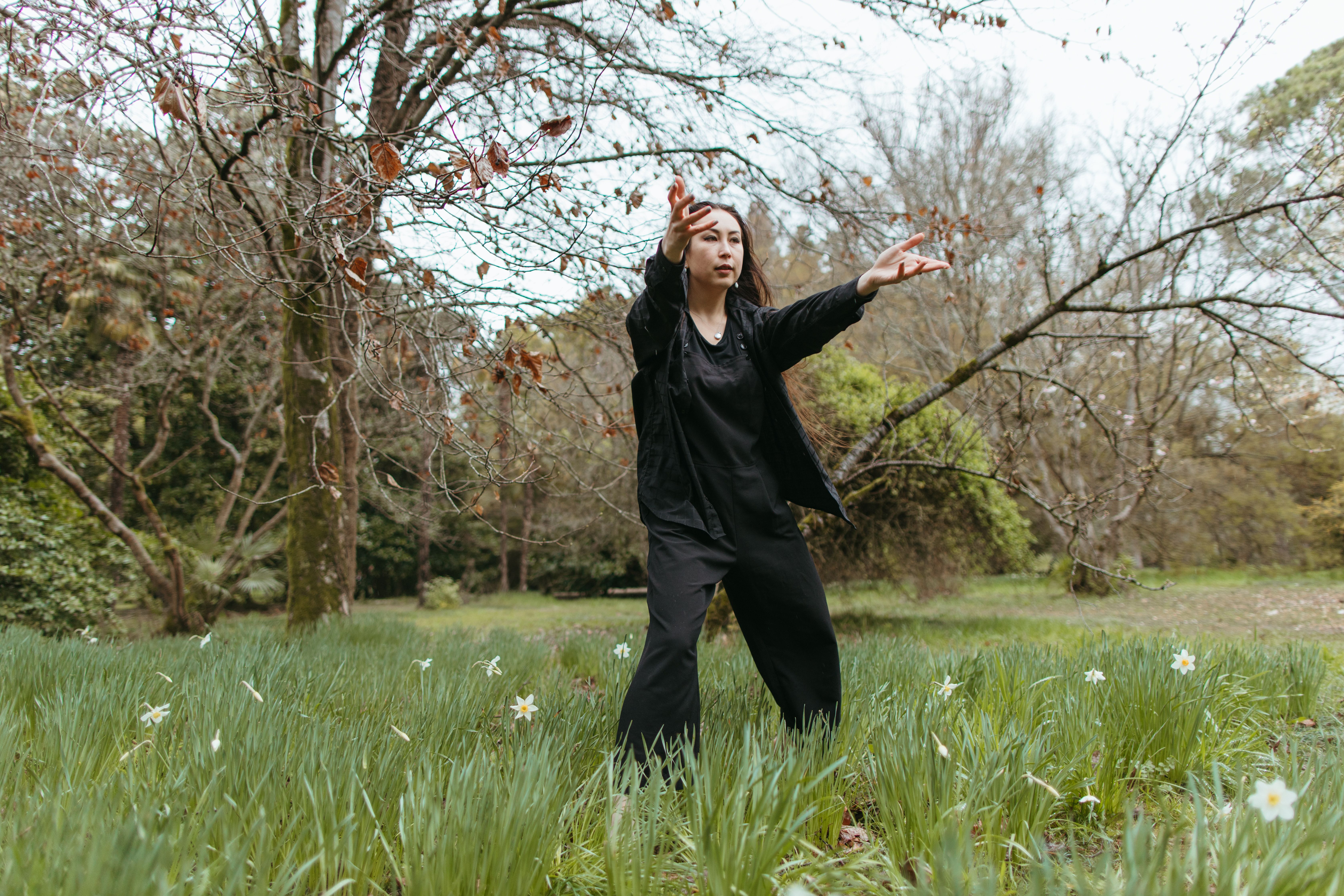 Woman in Black Jacket Dancing on Grass Field · Free Stock Photo