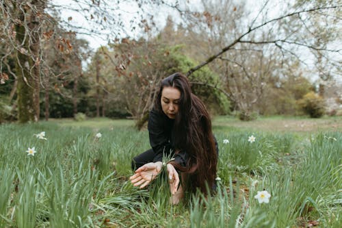 A Woman Sitting On The Grass Field