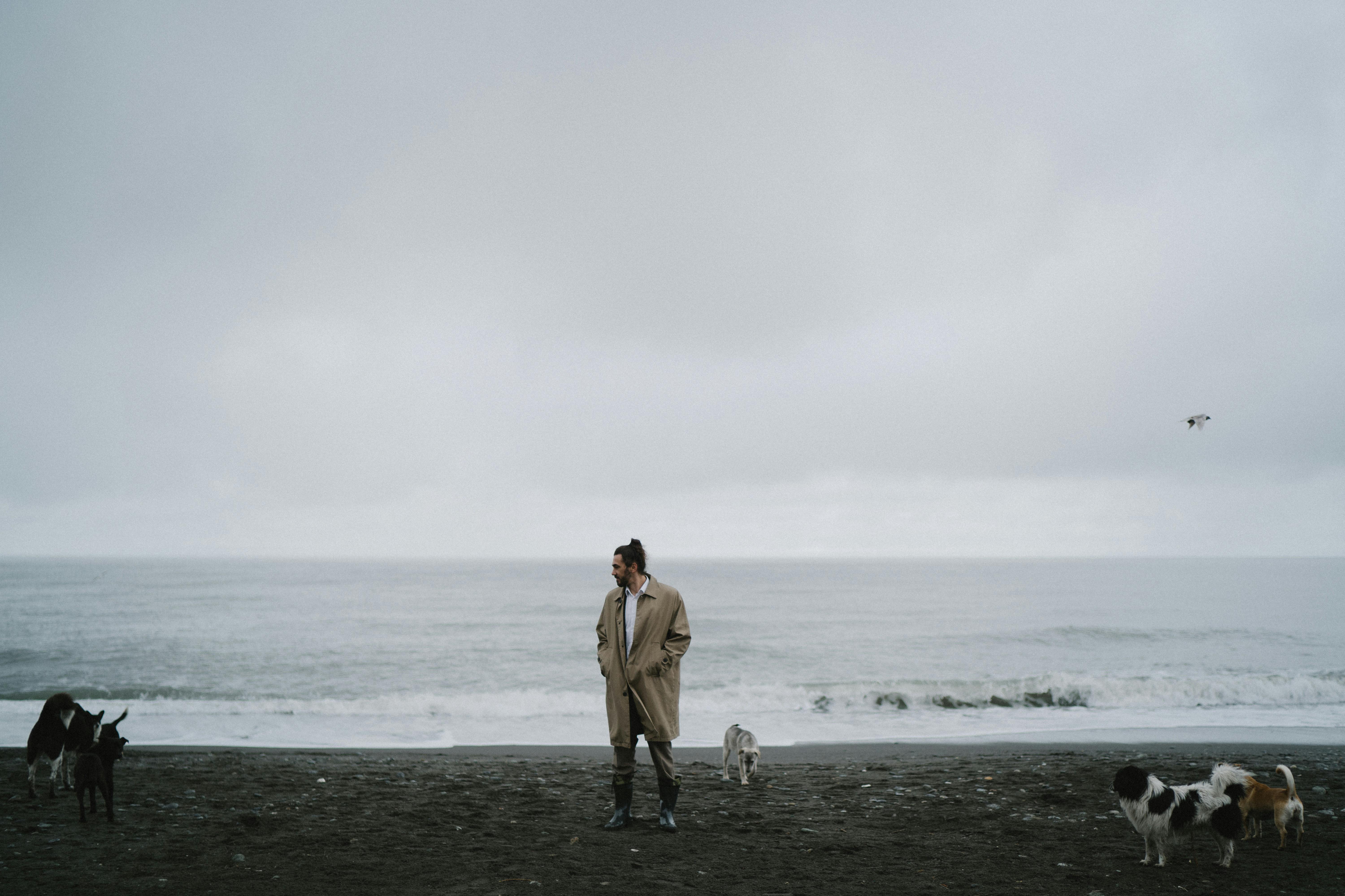 woman in brown coat standing on beach