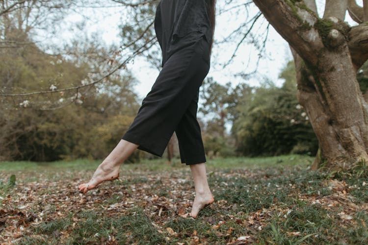 Person In Black Pants Walking Bare Feet On Ground