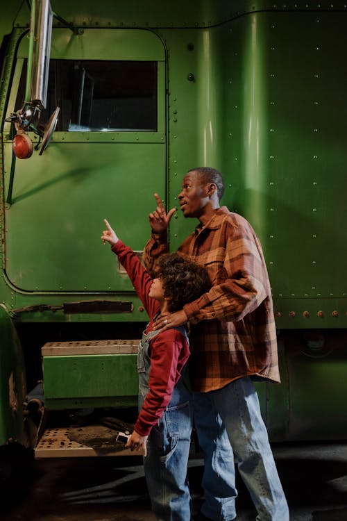 Free Man and a Boy Standing Beside a Truck Stock Photo
