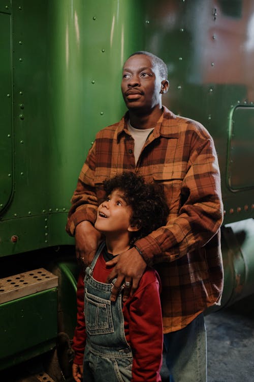 Man Standing with a Boy in a Denim Overalls