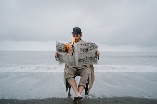 Free Man holding a Burning Newspaper  Stock Photo