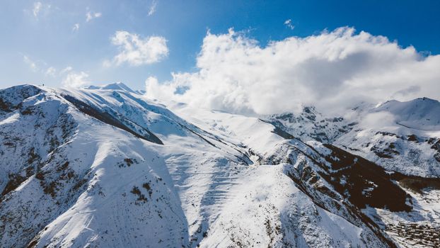 A breathtaking view of snow-covered mountains under a clear blue sky, capturing the serene beauty of winter.