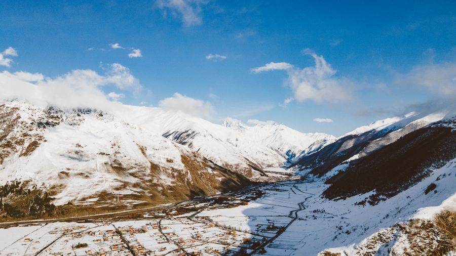Aerial view of a snow-covered valley and settlement — photo by ROMAN ODINTSOV on Pexels