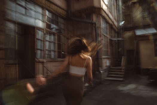 Artistic shot of a woman in motion with blurred background conveying speed and urban energy.