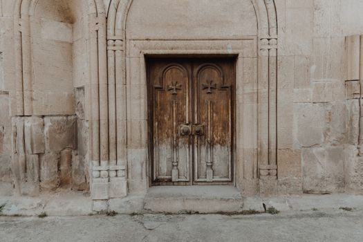 Ancient Wooden Door in a Stone Building 
