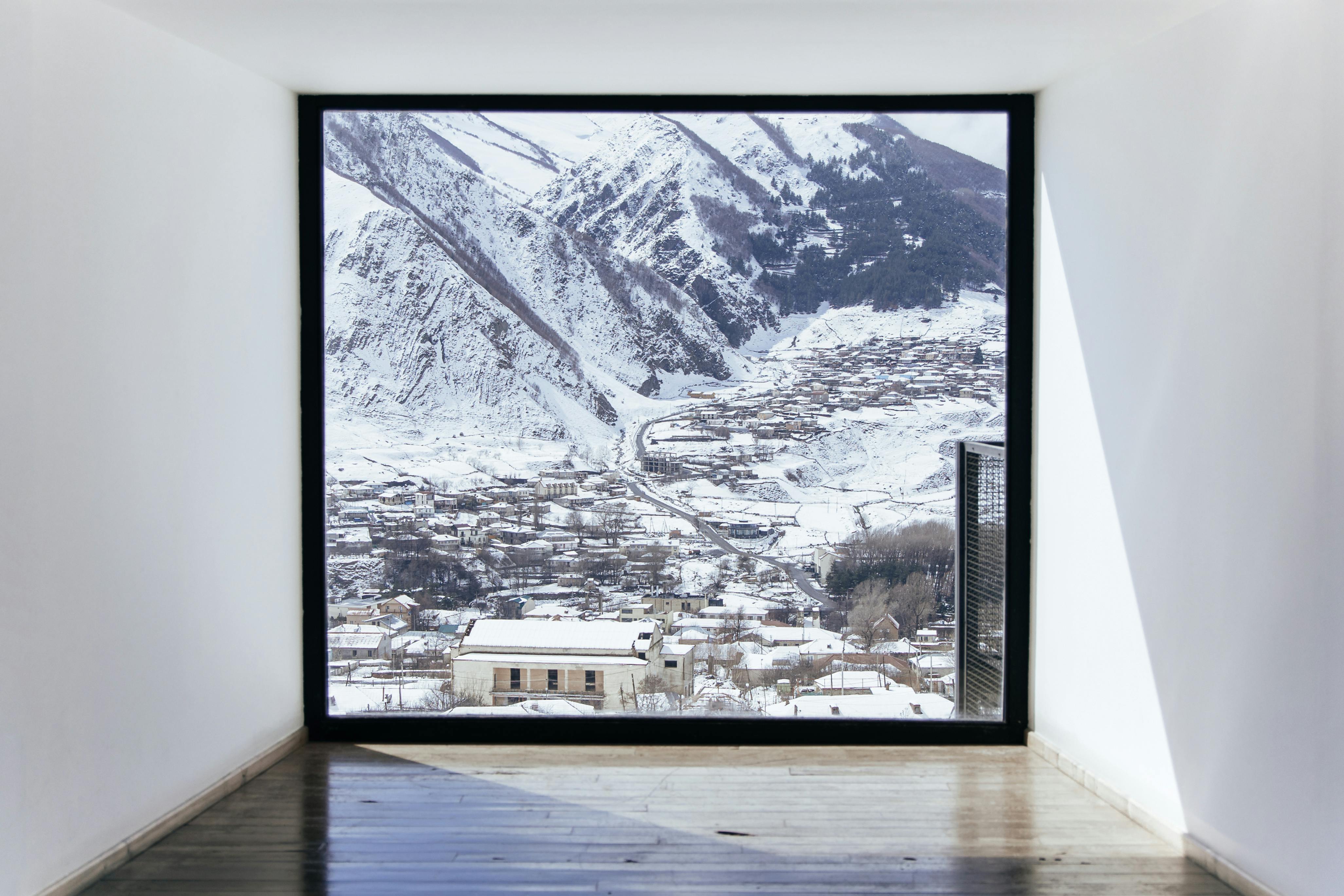 Prescription Goggle Inserts - Snow-covered mountain village seen through a modern window frame during winter.