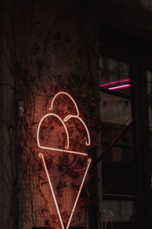 Free Illuminated neon ice cream sign on a wall, glowing in the night. Stock Photo