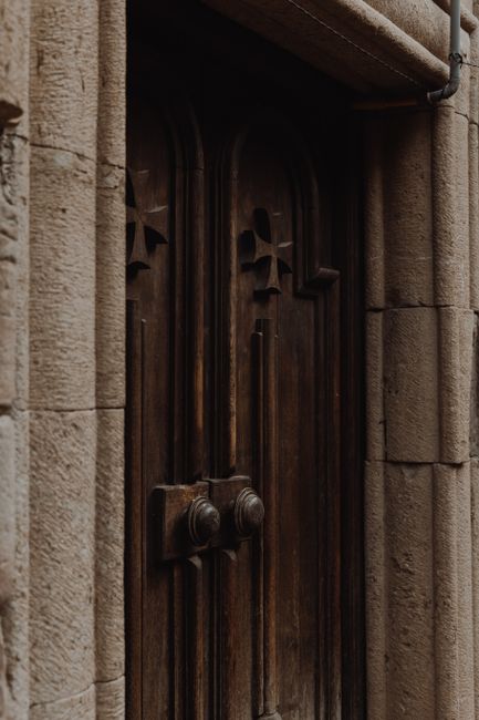 Close-up of an ancient wooden door with gothic carvings, offering a rustic and mysterious ambiance.