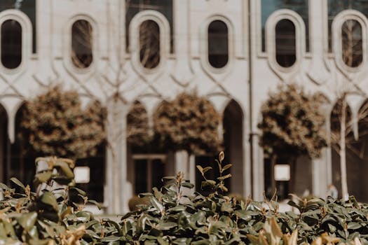Architectural facade with unique window design and lush greenery, perfect for urban themes.