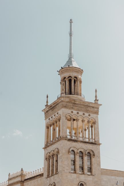 Vertical shot of a historic building tower against a blue sky, perfect for architecture themes.