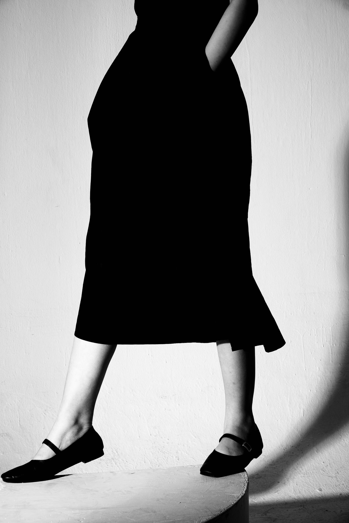 A woman in a skirt wearing Mary Jane flats — the strap that finishes a flat