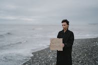 A Woman Holding a Placard on a Beach