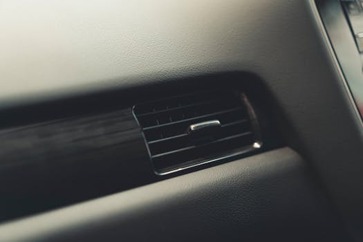 Detailed view of a car air vent system, showcasing interior design and texture.