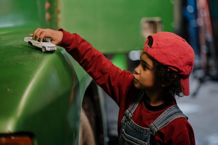 Boy In Red Long Sleeves Holding Toy Car