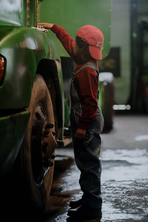 A Boy in Standing Beside the Car