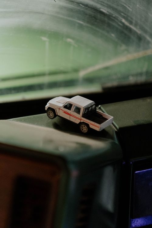 Free A toy truck rests on a dusty vehicle dashboard inside a car. Stock Photo