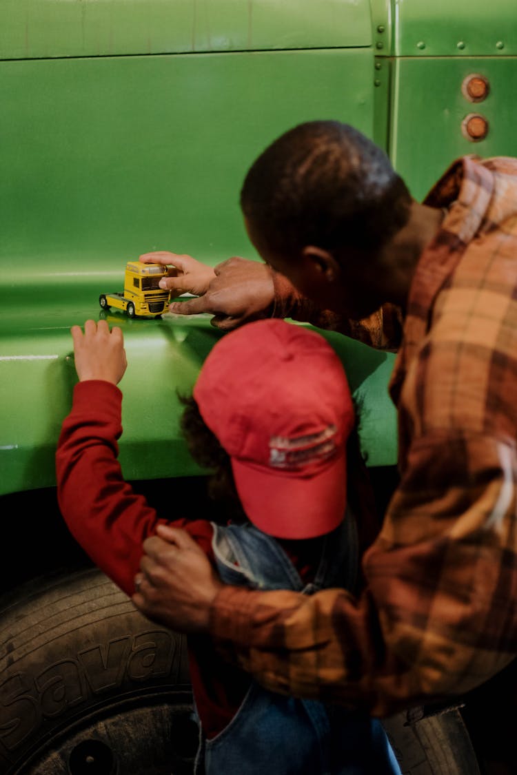 Father And Son Playing With A Car Toy