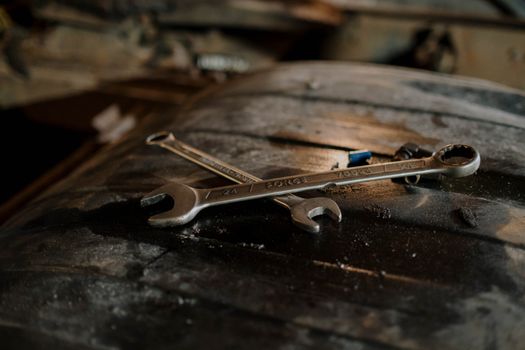 Close-up view of wrenches placed on a textured surface in a workshop setting.