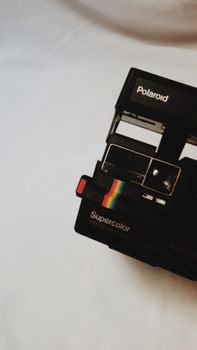 Close-up of a classic Polaroid camera with retro design elements on a soft background.