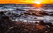 充满活力的日落映照在岩石海岸线上，波浪与风景秀丽的海景交相碰撞