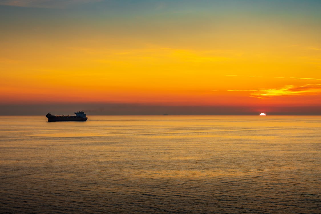 A Ship Sailing on the Ocean During Sunset