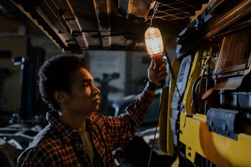 Man Wearing Plaid Shirt Holding a Trouble Light