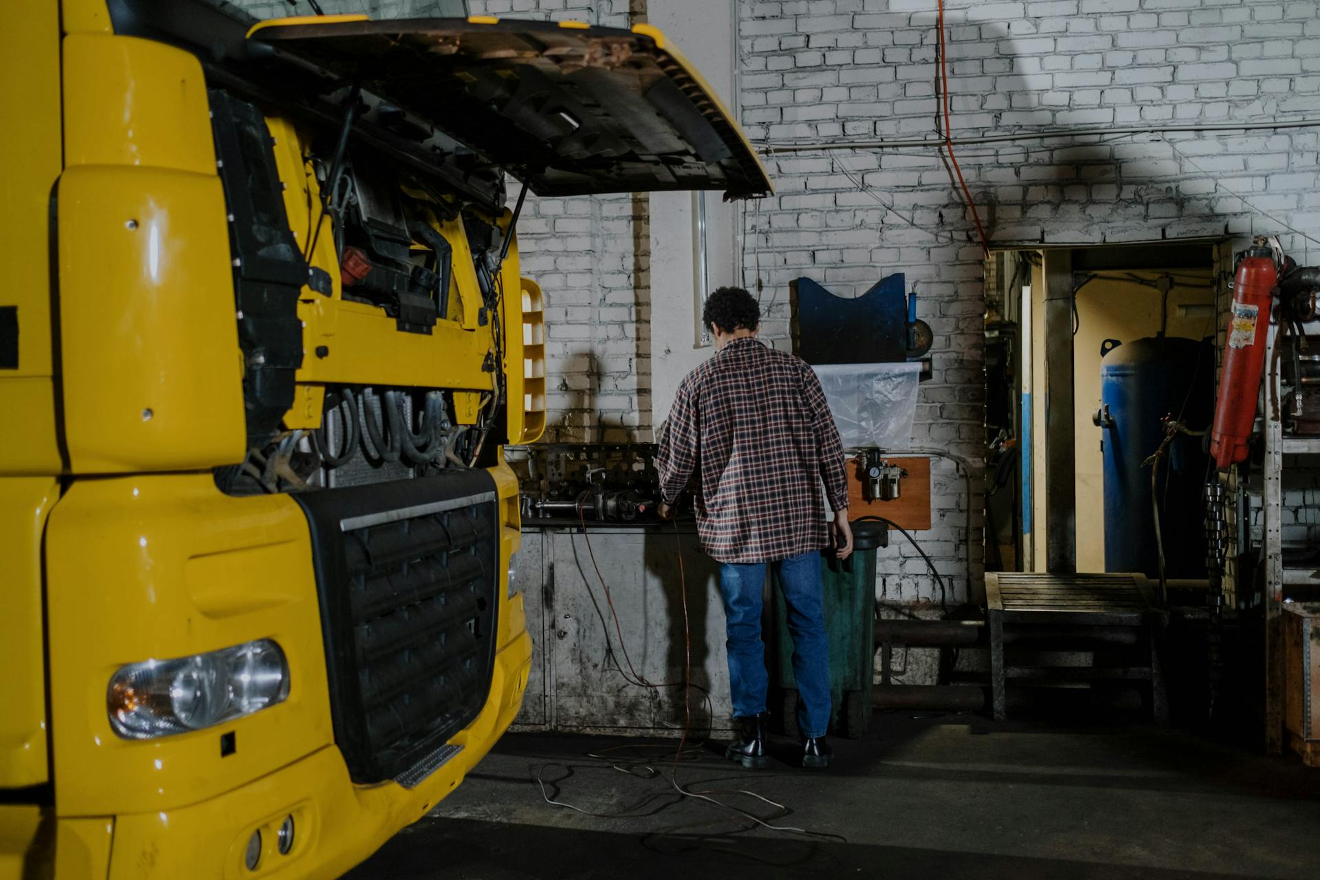 An Auto Mechanic Repairing Engine of a Truck