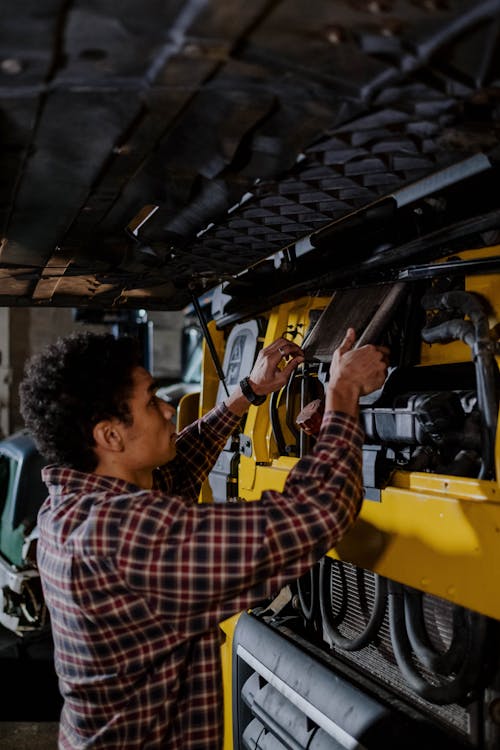 Man in Red and White Plaid Dress Shirt Holding Yellow Power Tool