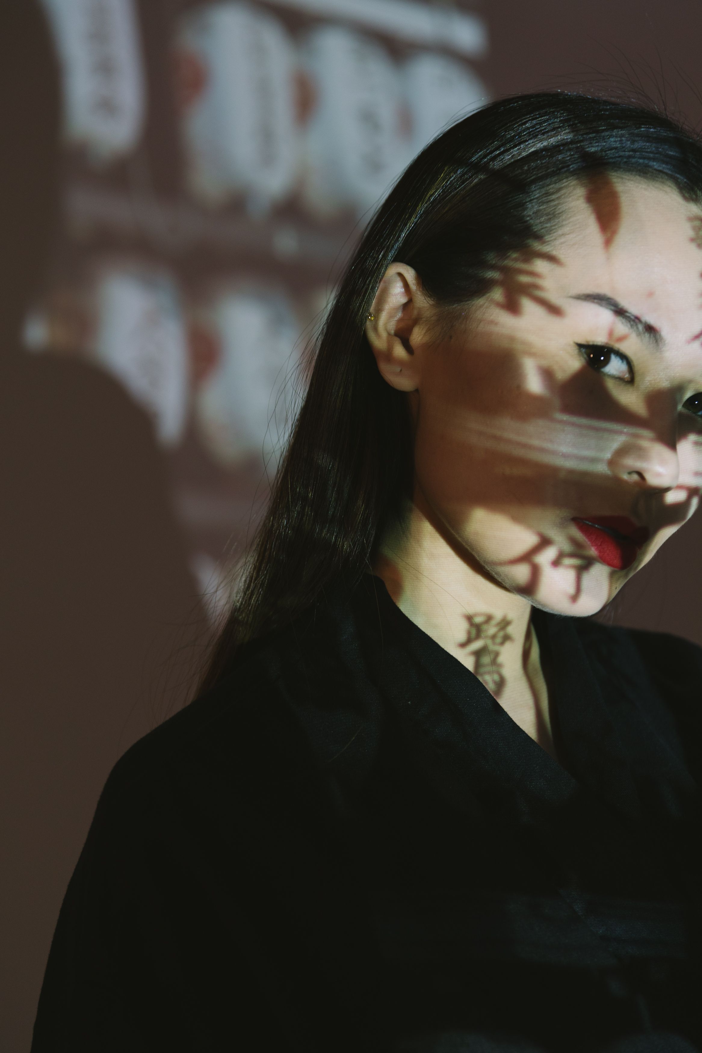 A striking portrait of a woman with shadows creating an artistic pattern on her face, conveying a mysterious mood.
