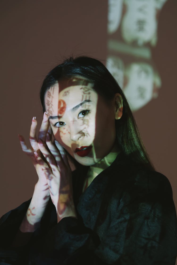 Woman In Black Top With Japanese Writing Reflected On Face