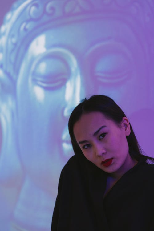 Woman Posing with Buddha Image on Background