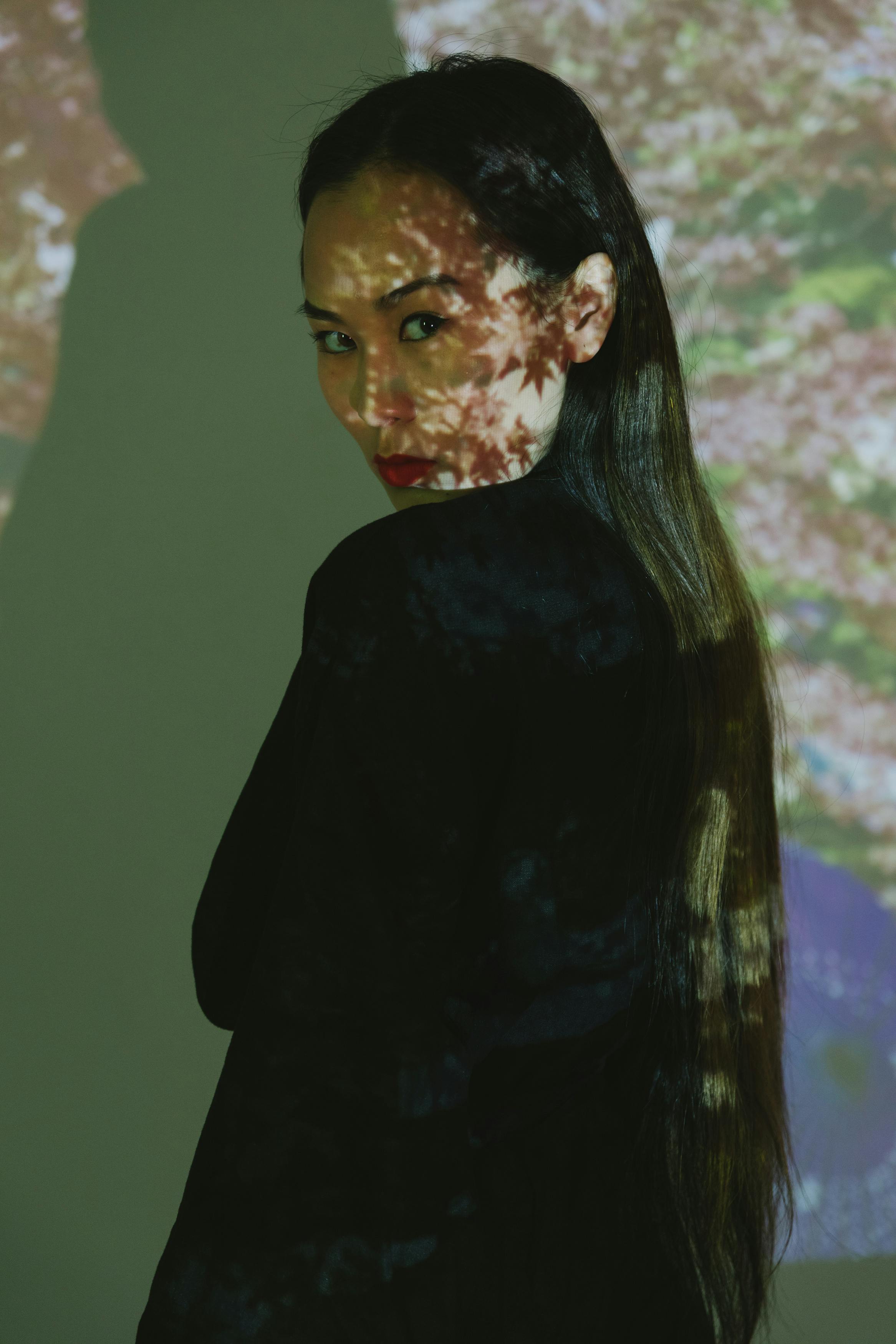 Creative portrait of a woman with intricate floral patterns projected onto her.