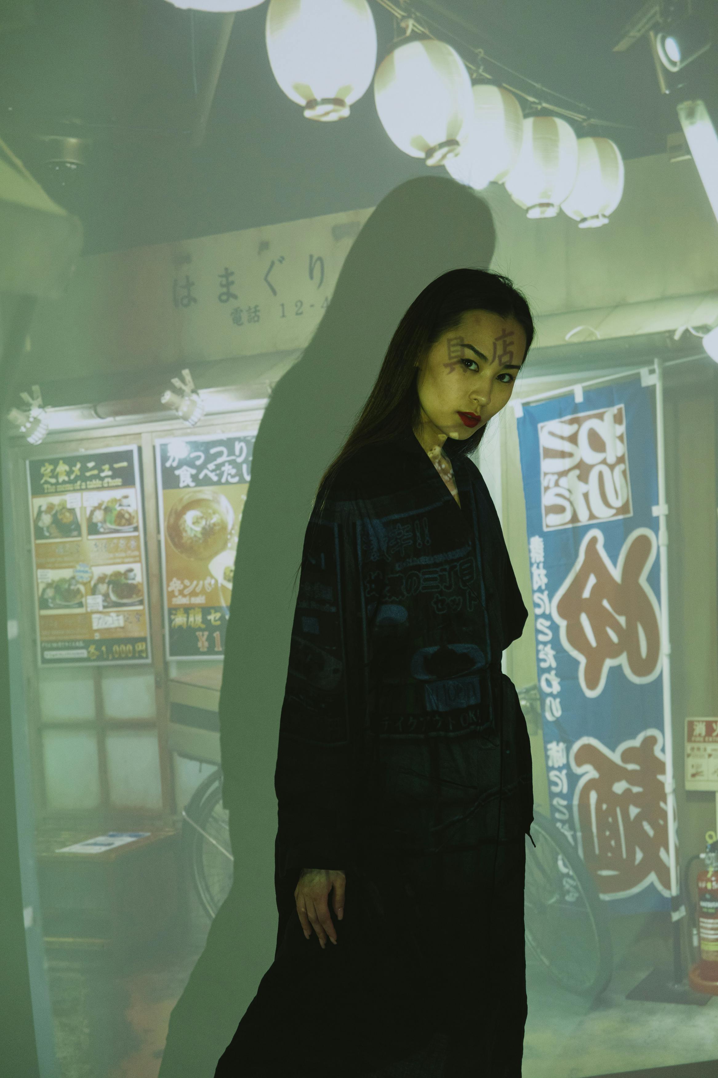 a woman standing in front of the projector light with storefront picture