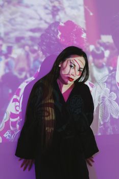 Portrait of a woman in black dress with vibrant projection art