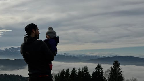 Free Man Holding a Baby in a Mountain Landscape Stock Photo