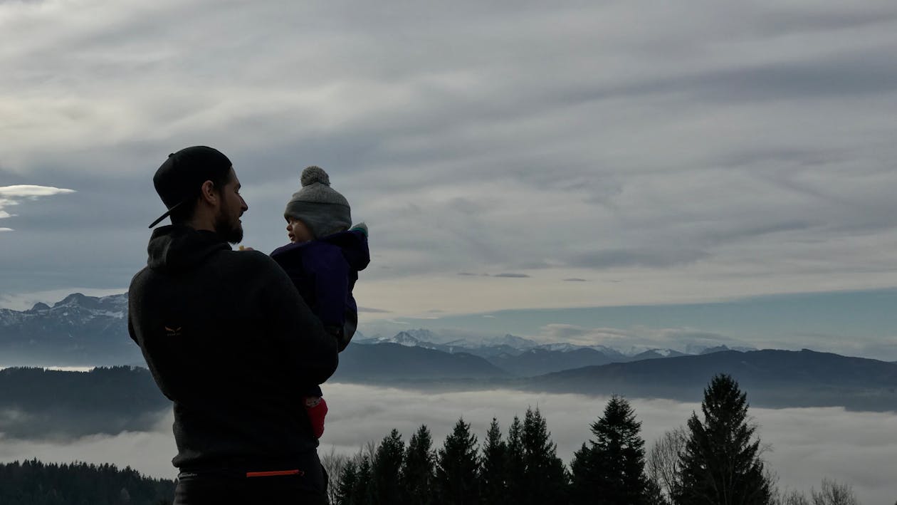 Man Holding a Baby in a Mountain Landscape