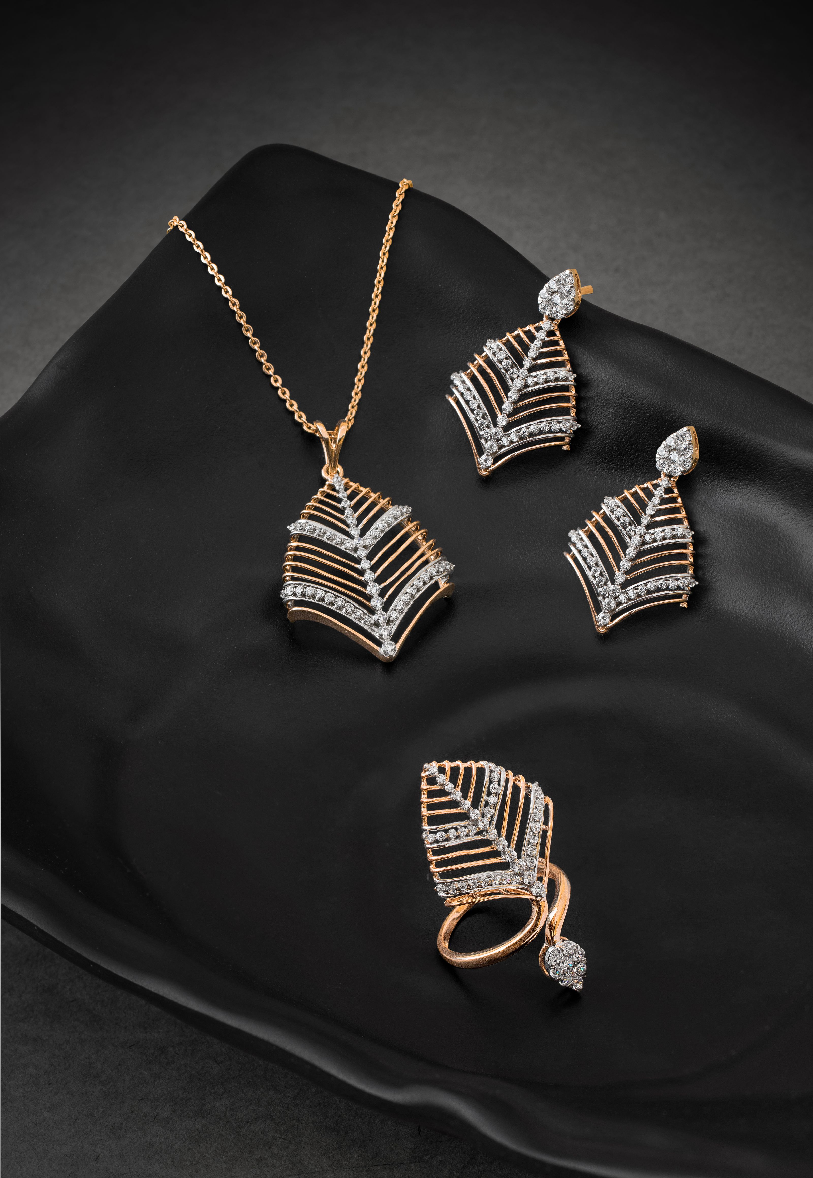 Conjunto elegante de colar de diamantes, brincos e anel exibido em um prato preto estiloso.