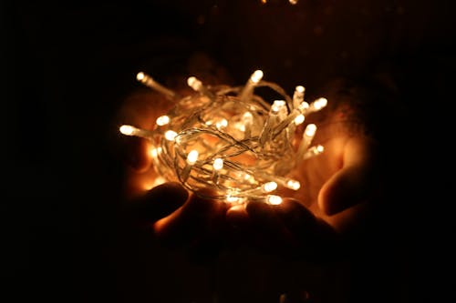 Person Showing White String Lights during Nightime