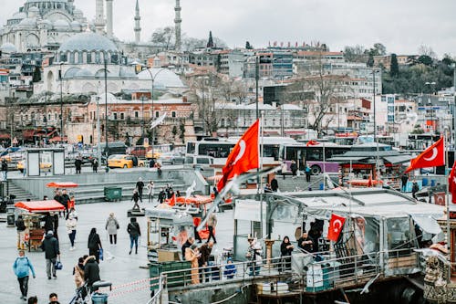 Crowded city street against mosques in cloudy day