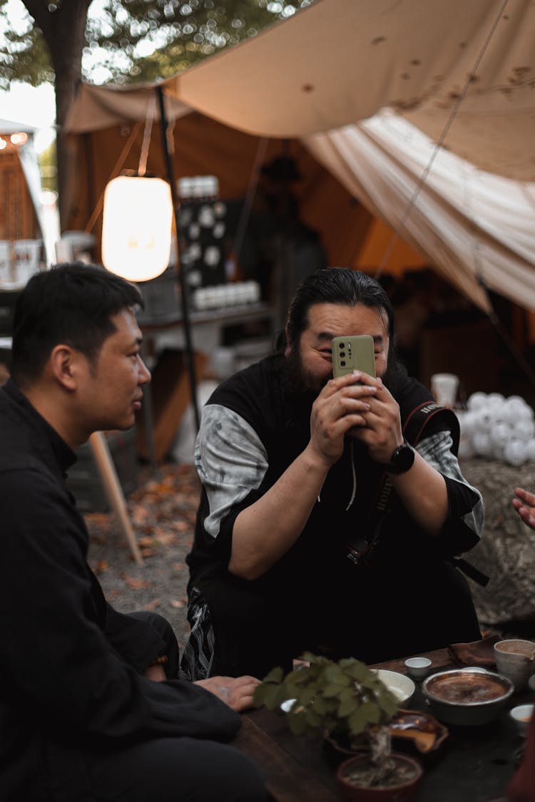 Man Holding Smartphone Against Face