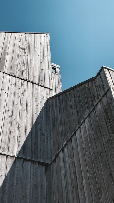 Photo by David Underland on Pexels Low-angle view of a wooden building with modern design against a blue sky in Alkmaar, Netherlands.