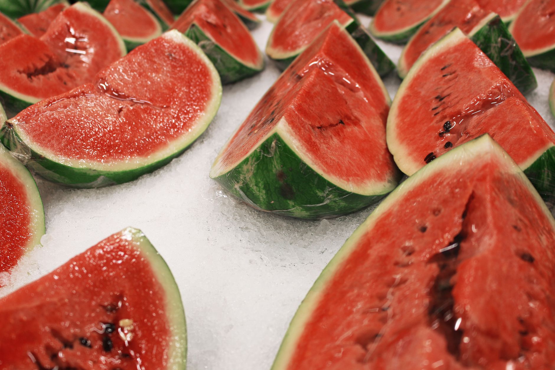 Juicy watermelon slices arranged on ice, perfect for a refreshing summer treat.