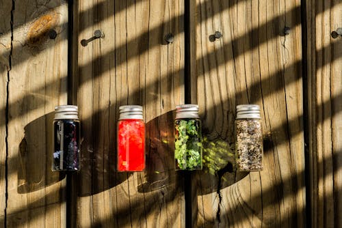 Varias Botellas De Vidrio De Varios Colores En La Mesa
